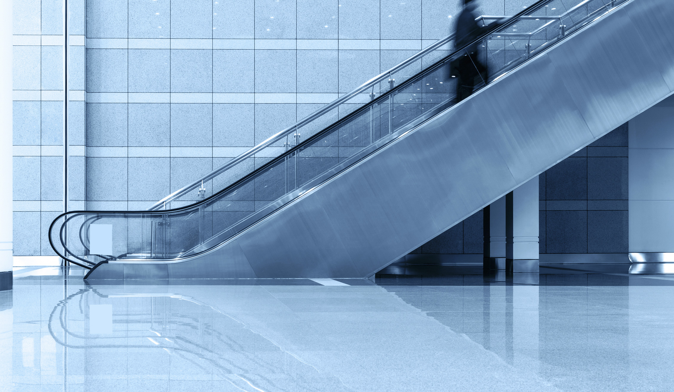 Person riding up an escalator symbolizing Adams + Miles team promotions