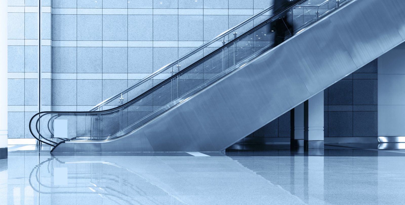 Person riding up an escalator symbolizing Adams + Miles team promotions